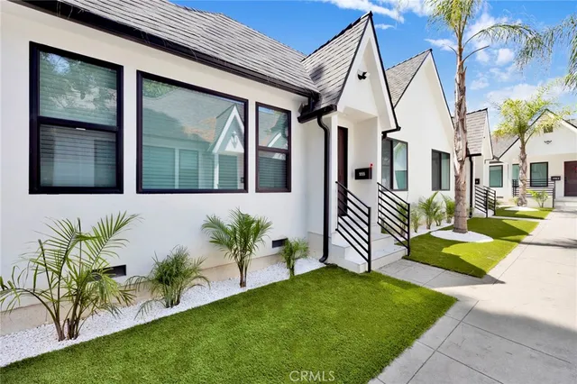a front view of a house with a garden and plants