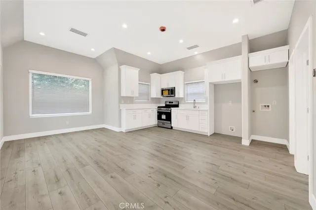 a view of a kitchen with wooden floor and a refrigerator