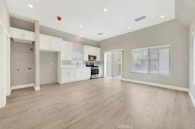 a view of empty room with wooden floor and window