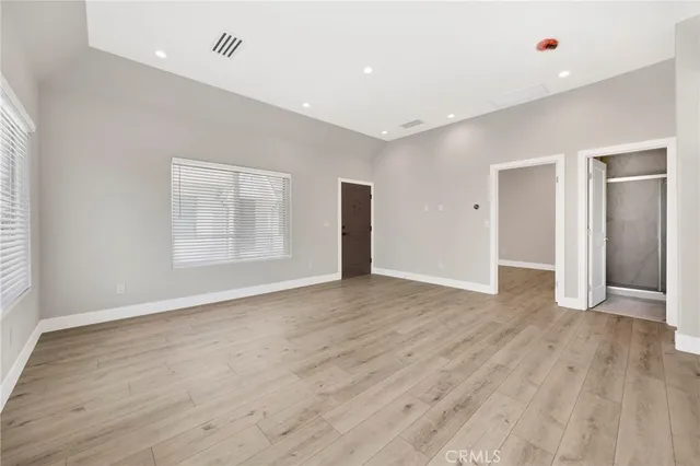 an empty room with wooden floor & bathroom