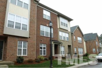 a front view of a residential apartment building with a yard