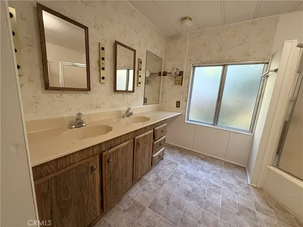 a spacious bathroom with a double vanity sink and mirror