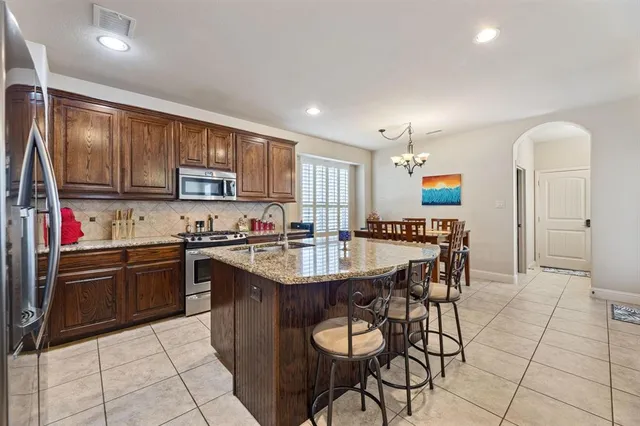 a kitchen with stainless steel appliances granite countertop a stove refrigerator sink and cabinets