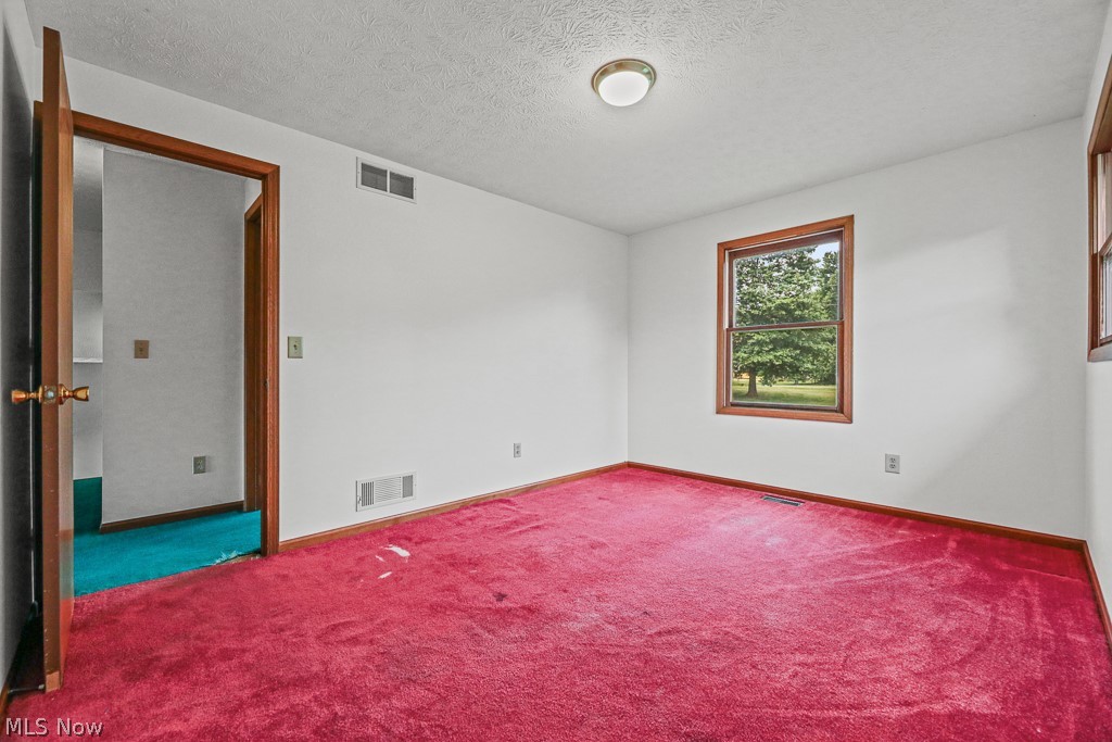 2642 Blake Road Wadsworth, OH 44281 - Photo 26 of 46 Room featuring red carpeting, white walls, and a wood-trimmed window