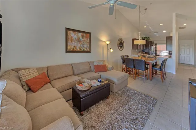a living room with furniture a rug and kitchen view