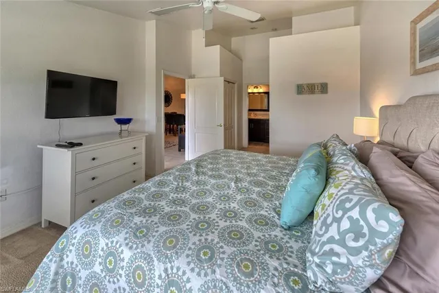a living room with a bed and flat screen tv