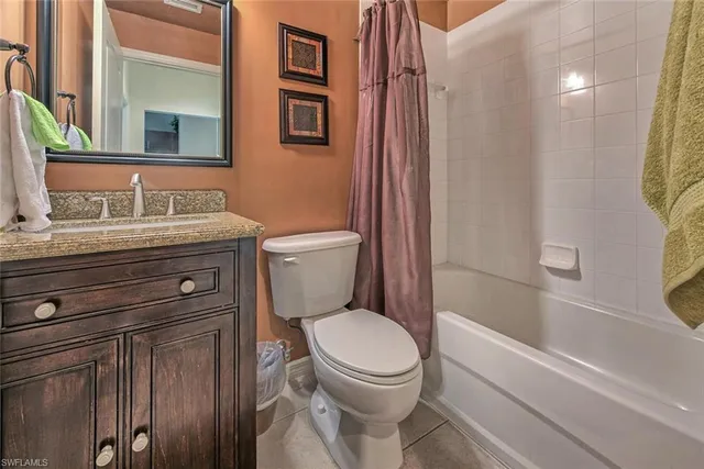 a bathroom with a granite countertop toilet sink and mirror