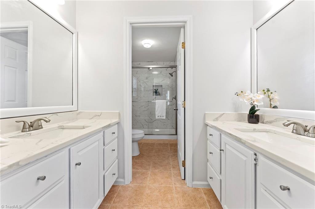 5401 Tower Road Greensboro, NC 27410 - Photo 11 of 21 Dual vanity leading to the tile surround shower