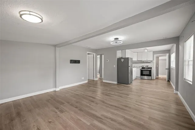 a view of a kitchen with wooden floor and an empty space