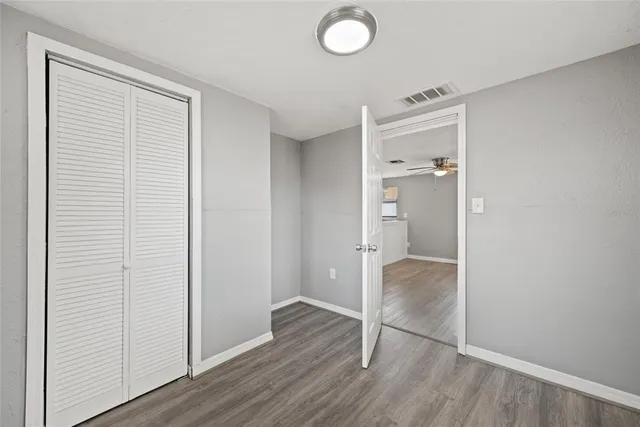 an empty room with wooden floor & bathroom