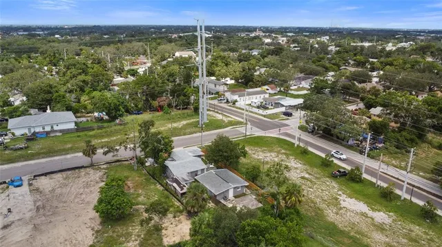 an aerial view of residential houses with outdoor space and trees