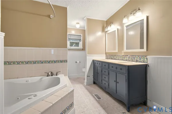 a bathroom with a bathtub a mirror and a sink