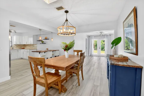 a view of a dining room with furniture a chandelier and wooden floor