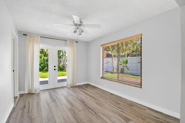 a view of an empty room with a window and wooden floor