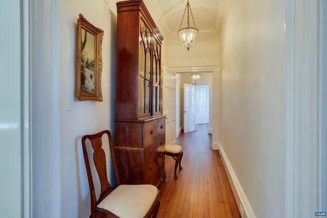 a view of a hallway with furniture and wooden floor