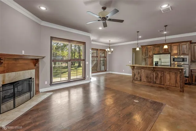 a view of a livingroom with furniture a ceiling fan and wooden floor