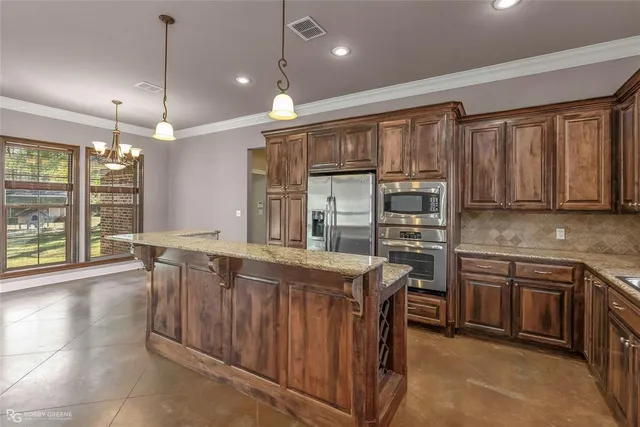 a kitchen with stainless steel appliances granite countertop a stove a sink and a refrigerator