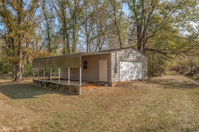 front view of a house with a yard and a large tree