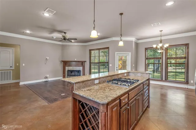 a kitchen with kitchen island a large island in the center windows and wooden floor