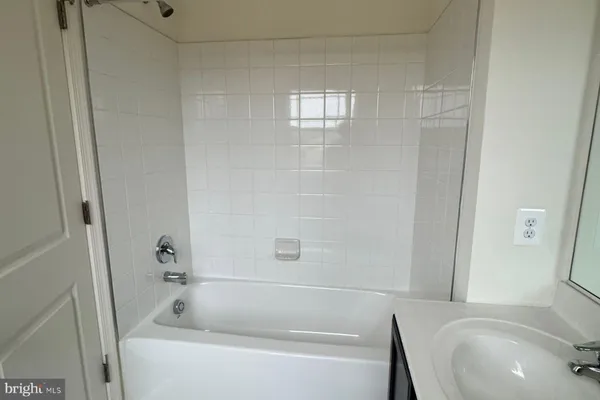 a bathroom with a sink and bathtub with shower