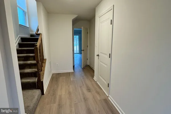 a view of a hallway with wooden floor and cabinets