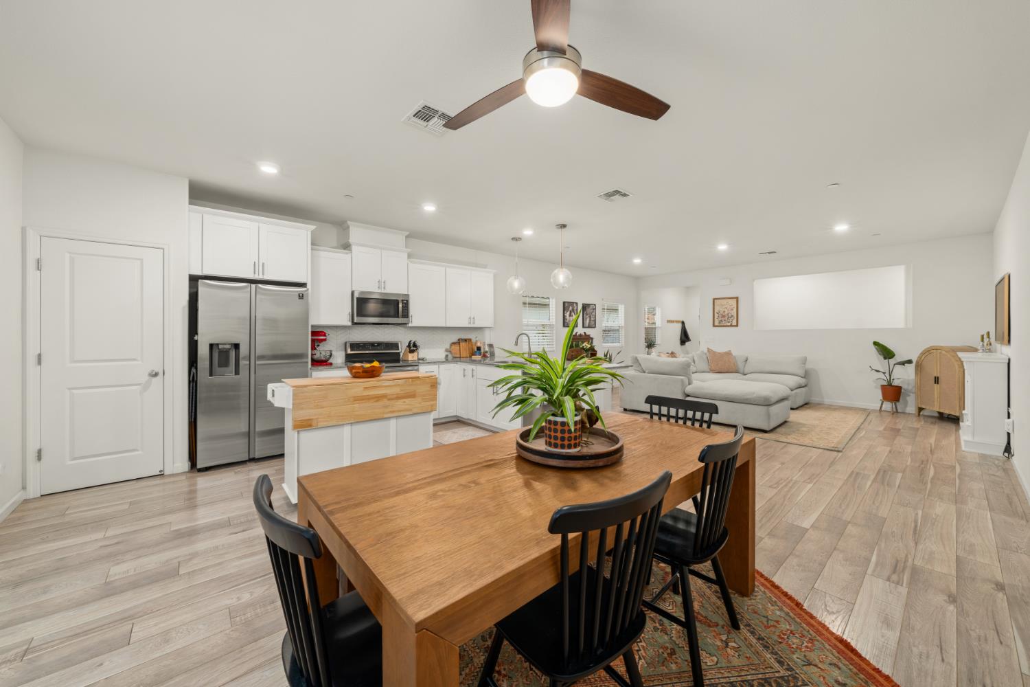 7457 Sobon Lane Rancho Murieta, CA 95683 - Photo 3 of 32 a kitchen with a dining table cabinets appliances and wooden floor
