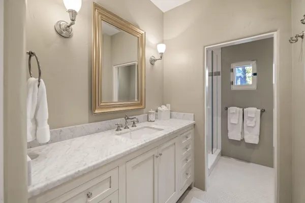 a spacious bathroom with a granite countertop sink and a mirror