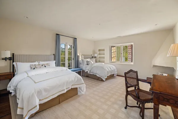 a bedroom with two beds and a window