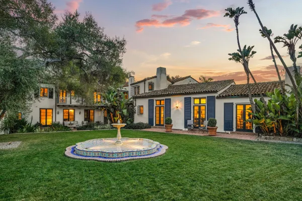 a front view of a house with a yard and trees