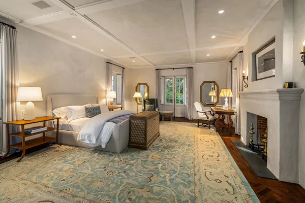 a bed room with a bed couches and a fireplace