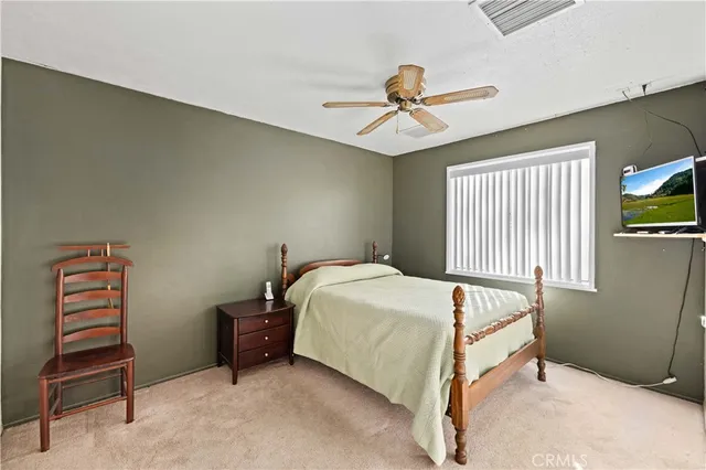 a bedroom with a bed and a ceiling fan