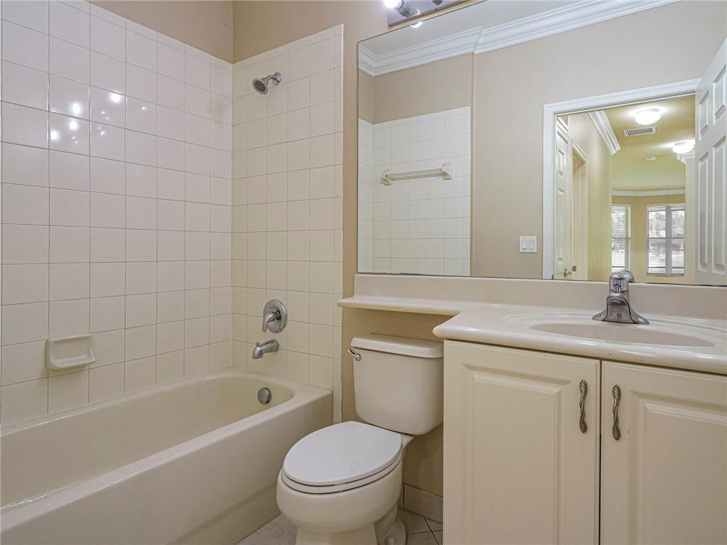 1931 Grey Falcon Circle Southwest Vero Beach, FL 32962 - Photo 13 of 36 a bathroom with a granite countertop toilet a sink a mirror a bathtub and shower