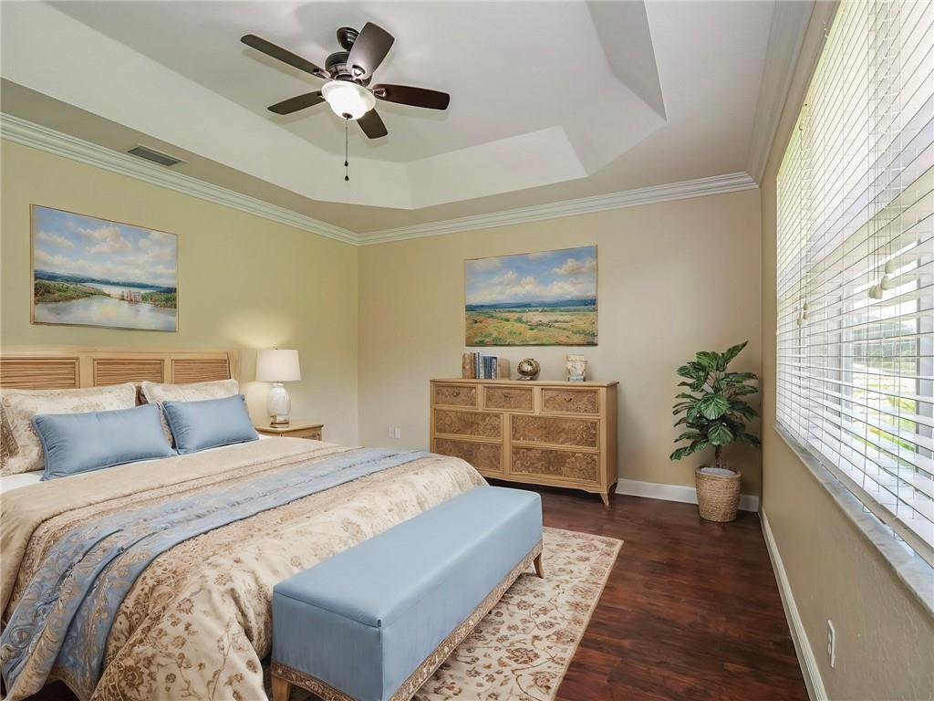 1931 Grey Falcon Circle Southwest Vero Beach, FL 32962 - Photo 15 of 36 a bedroom with bed and a chandelier