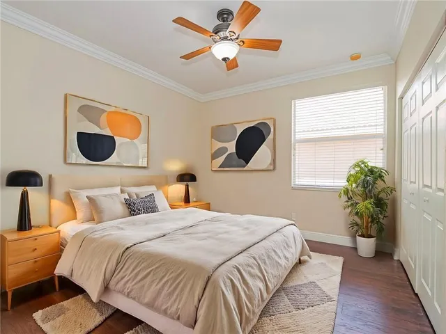 an empty room with wooden floor chandelier fan and windows