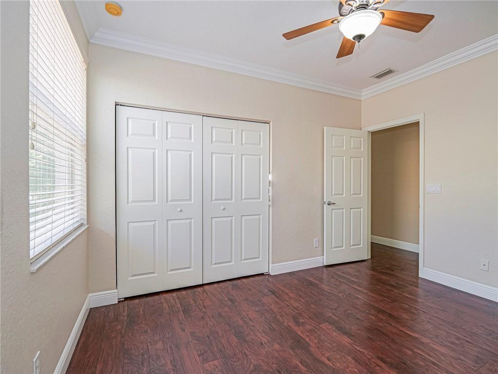 1931 Grey Falcon Circle Southwest Vero Beach, FL 32962 - Photo 20 of 36 an empty room with wooden floor chandelier fan and windows