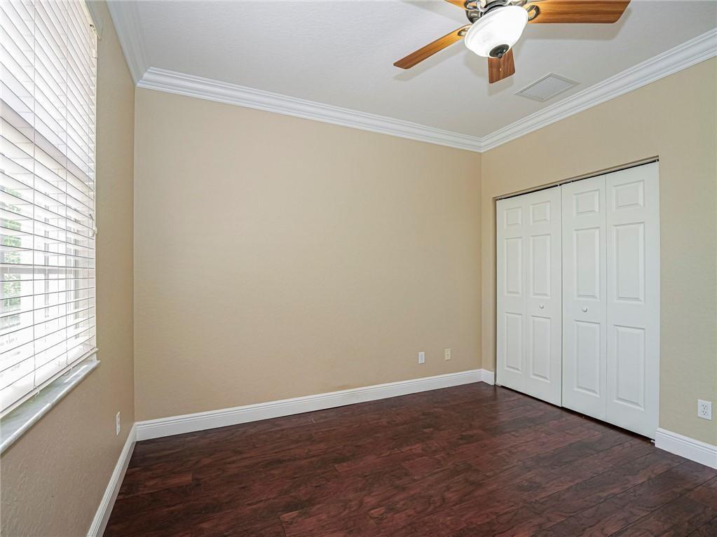 1931 Grey Falcon Circle Southwest Vero Beach, FL 32962 - Photo 24 of 36 an empty room with wooden floor and windows