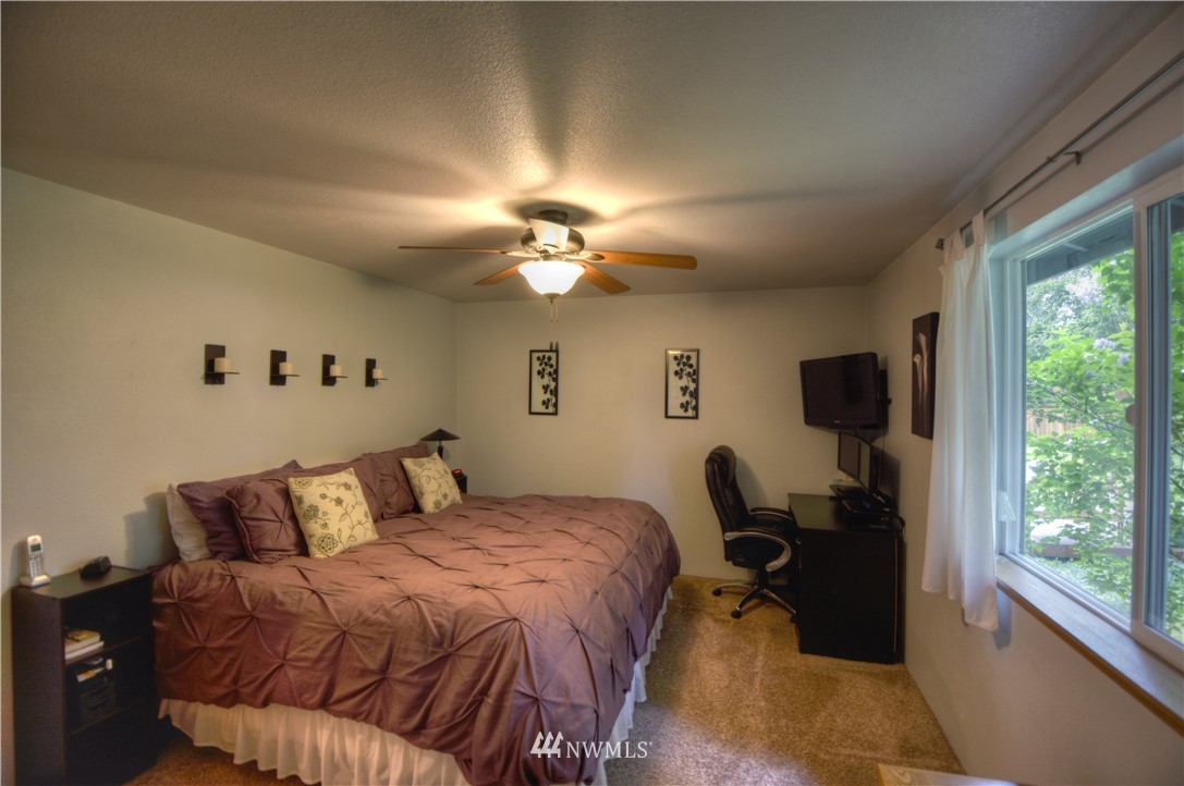 5423 187th Court Southwest Rochester, WA 98579 - Photo 13 of 24 a bedroom with a bed and a chandelier