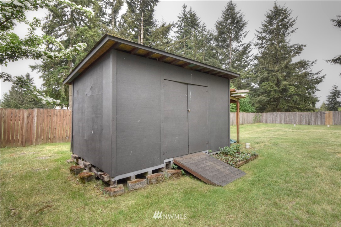 5423 187th Court Southwest Rochester, WA 98579 - Photo 23 of 24 a view of backyard with wooden fence and trees
