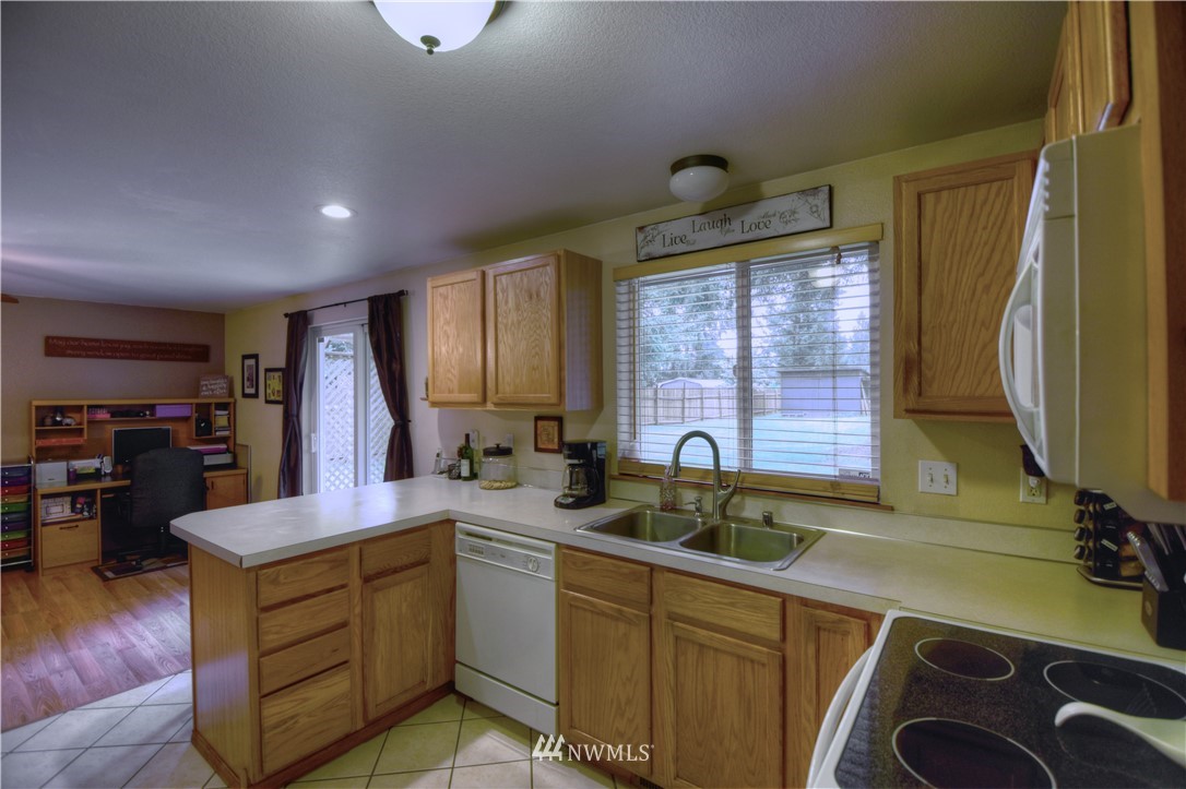5423 187th Court Southwest Rochester, WA 98579 - Photo 6 of 24 a kitchen with sink cabinets and wooden floor