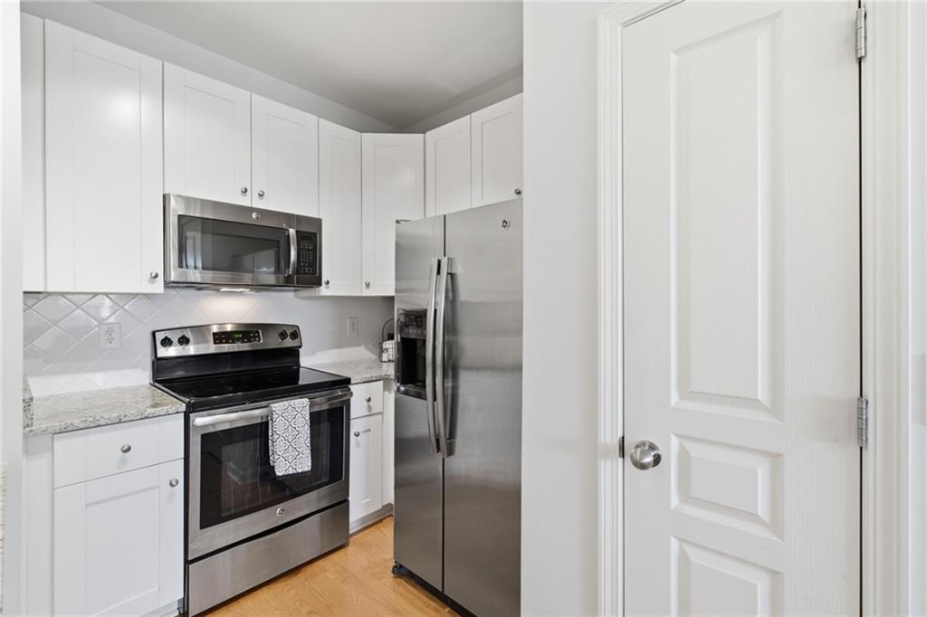 10 Perimeter Summit Boulevard, Unit 4439 Atlanta, GA 30319 - Photo 15 of 69 a kitchen with stainless steel appliances granite countertop white cabinets and a refrigerator