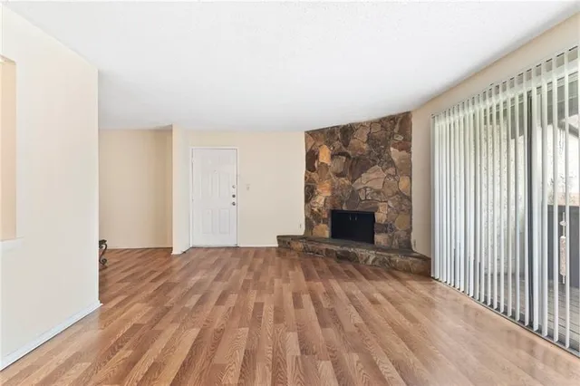 a view of an empty room with a fireplace and a window