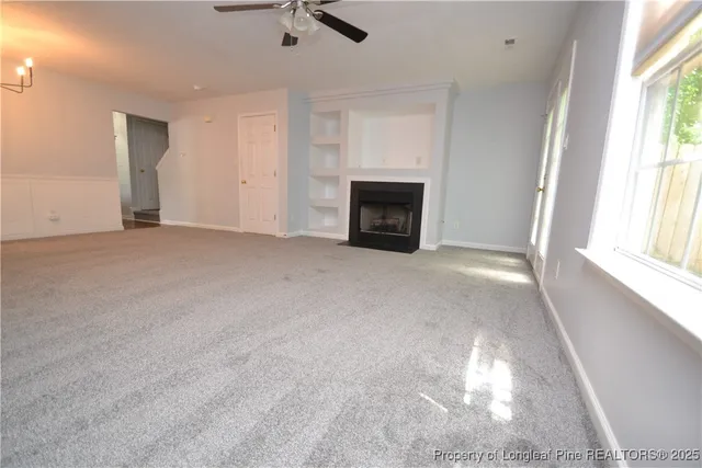 an empty room with fireplace and windows