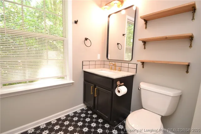 a bathroom with a toilet a sink and a window