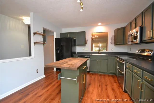 a kitchen with stainless steel appliances granite countertop a sink and a refrigerator