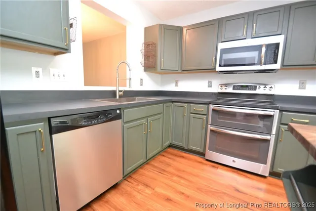 a kitchen with stainless steel appliances granite countertop a sink and a microwave