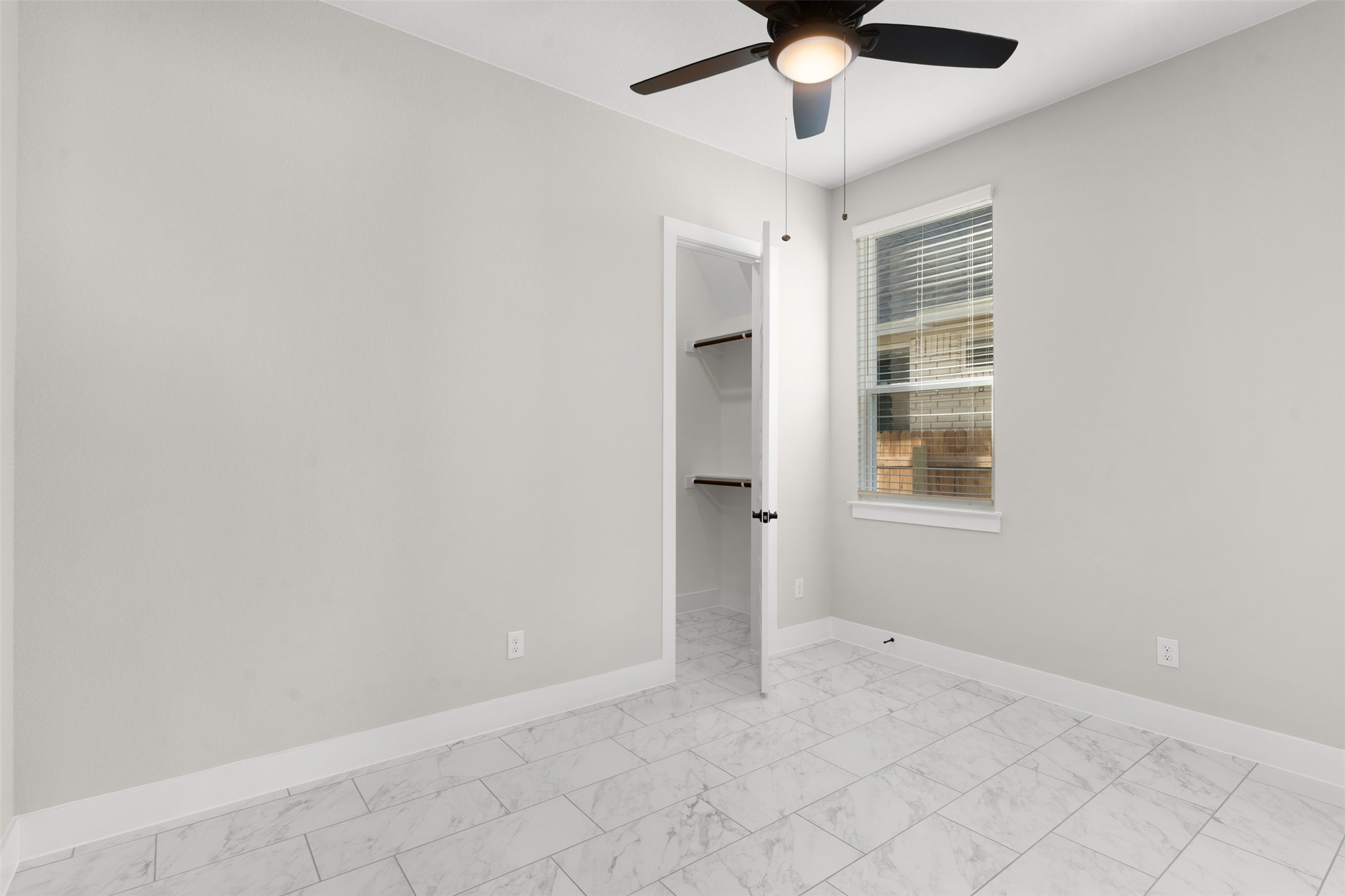 17216 Hope Bergman Road Pflugerville, TX 78660 - Photo 22 of 30 Unfurnished bedroom with a spacious closet, a ceiling fan, and light marble finish floors