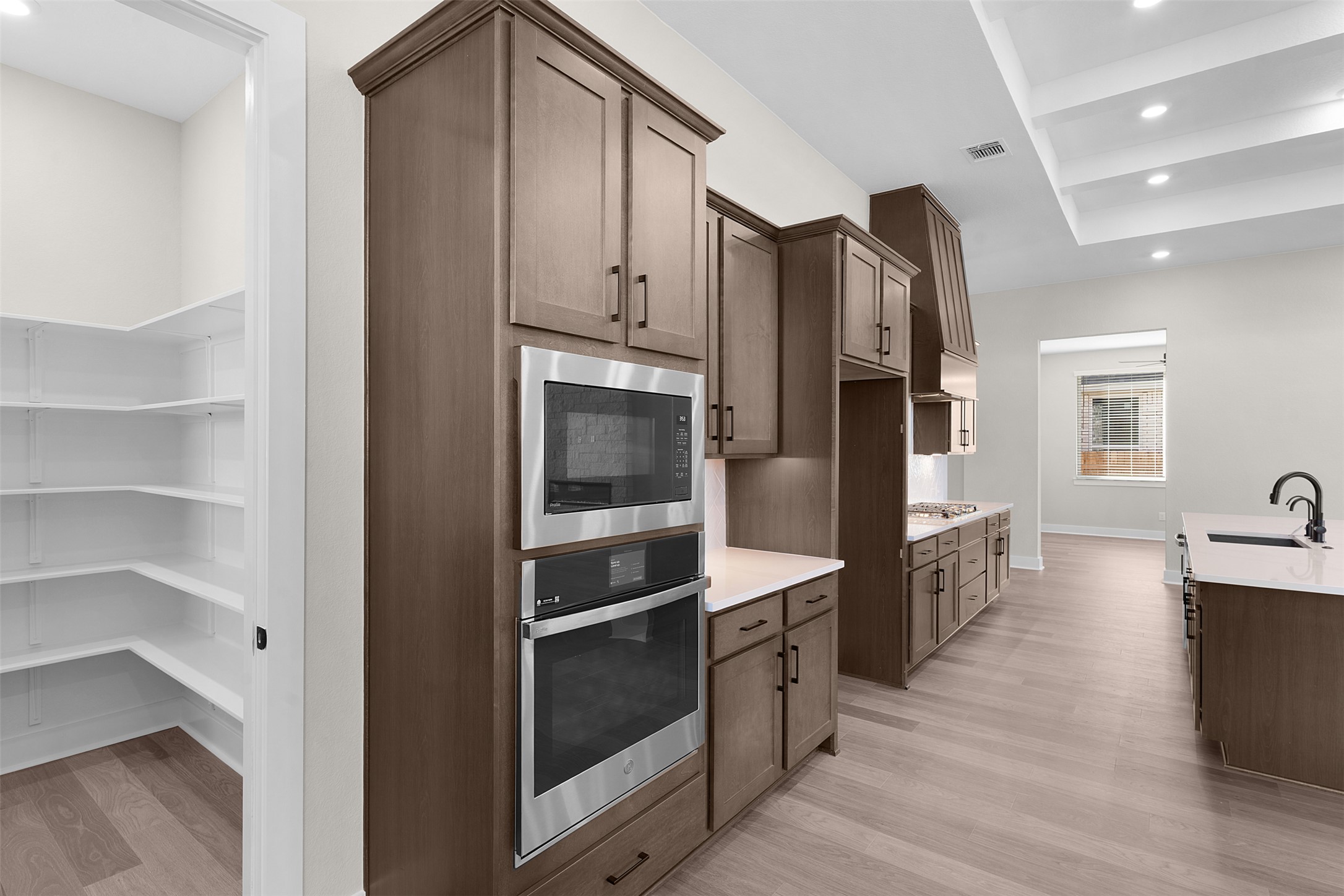 17216 Hope Bergman Road Pflugerville, TX 78660 - Photo 10 of 30 Kitchen with recessed lighting, oven, built in microwave, light wood-type flooring, and light stone counters