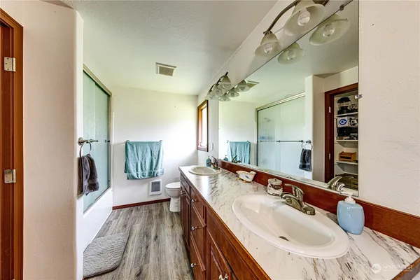 a en suite bathroom with a double vanity sink and a mirror