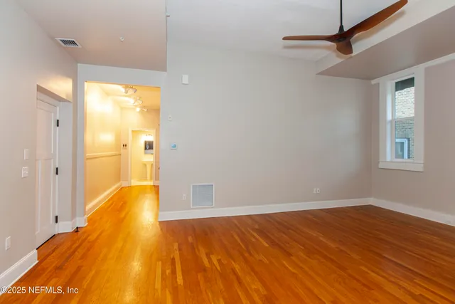 a view of a room with wooden floor and a bathroom