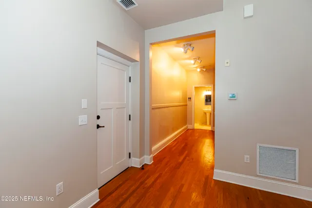 a view of a hallway with wooden floor